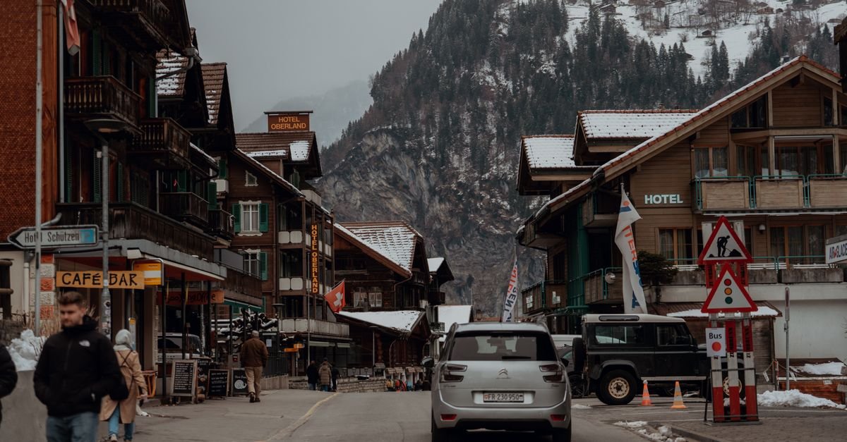 Rue d'un village alpin en hiver, chalets en bois sous la neige