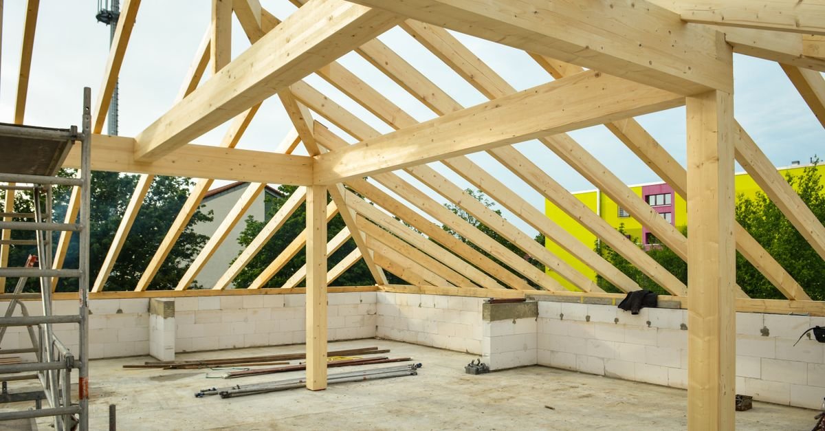 Charpente en bois en cours de montage sur un bâtiment en béton